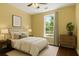 This staged bedroom features a plush bed with a neutral color palette and hardwood floors at 4637 Bonnie Marie Way, North Charleston, SC 29405