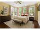 This staged bedroom features natural light, neutral tones, plush bedding, and hardwood floors at 4637 Bonnie Marie Way, North Charleston, SC 29405