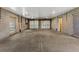 A large garage with concrete flooring, cinder block walls, two windows and two garage doors at 4637 Bonnie Marie Way, North Charleston, SC 29405