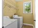 Bright laundry room featuring a washer, dryer, storage shelves, and a window for natural light at 4637 Bonnie Marie Way, North Charleston, SC 29405