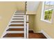 Staircase with hardwood steps and white risers, showcasing a classic design and bright natural light at 4637 Bonnie Marie Way, North Charleston, SC 29405