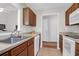 Well-lit kitchen with wood cabinets, tile floors, and a double sink at 4856 Carnoustie Ct, Summerville, SC 29485