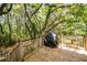 Wooden deck with a covered grill and railing, surrounded by lush trees and greenery at 4991 Sound View Dr, Mount Pleasant, SC 29466