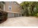 Spacious three car garage with concrete driveway and lush, natural surroundings at 4991 Sound View Dr, Mount Pleasant, SC 29466
