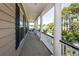 Long porch with white columns provides plenty of space and natural light with wooded scenery at 4991 Sound View Dr, Mount Pleasant, SC 29466