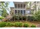 Rear exterior view of home featuring large screened-in porch and well-manicured landscaping at 4991 Sound View Dr, Mount Pleasant, SC 29466