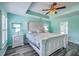 This primary bedroom features light blue walls, a ceiling fan and grey wood floors for a tranquil and relaxing atmosphere at 5032 Ballantine Dr, Summerville, SC 29485