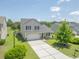 Beautiful home exterior featuring lush landscaping, a covered porch, and a spacious driveway at 5032 Ballantine Dr, Summerville, SC 29485