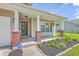 Inviting front porch with brick columns, hanging plants, and a decorative wreath on the front door at 5032 Ballantine Dr, Summerville, SC 29485