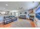 Cozy living room with hardwood floors, fireplace, ceiling fan, and stylish black leather couches at 5032 Ballantine Dr, Summerville, SC 29485