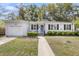 Charming single-story home featuring a blue door, manicured bushes, and an attached garage at 5075 Walker St, North Charleston, SC 29405