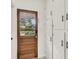 Hallway featuring a wood door with glass panels and white storage cabinets with black hardware at 5075 Walker St, North Charleston, SC 29405