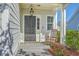 Charming front porch with a rocking chair next to a black door with a hanging lantern light fixture at 508 Alderly Dr, Moncks Corner, SC 29461