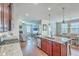 Kitchen with granite countertops, a center island, wood cabinetry, and open flow to a living room with a fireplace at 508 Alderly Dr, Moncks Corner, SC 29461
