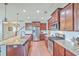 Open kitchen features stainless steel appliances, a large island with granite countertops, and dark wood cabinets at 508 Alderly Dr, Moncks Corner, SC 29461