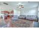 Bright, open-concept living area with hardwood floors, ceiling fan, and comfortable leather seating at 508 Alderly Dr, Moncks Corner, SC 29461