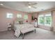Bright main bedroom featuring a tufted headboard, neutral carpet, three windows, and fresh paint at 511 Nandina Dr, Goose Creek, SC 29445