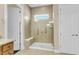 Modern bathroom featuring a tiled shower with glass door, bench, and grab bars for convenience at 522 Tidewater Chase Ln, Summerville, SC 29486
