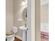 Half bath featuring a pedestal sink, toilet, and wood floors at 522 Tidewater Chase Ln, Summerville, SC 29486