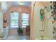 Bright bathroom featuring a tiled shower with butterfly accents, a pedestal sink and a large window at 5615 Highway 165, Ravenel, SC 29470