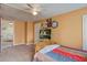 Comfortable bedroom with orange walls, ceiling fan, and a bed with colorful bedding, plus television at 5615 Highway 165, Ravenel, SC 29470