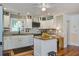 Bright kitchen with stainless steel appliances, island with granite countertops, and white cabinets at 5615 Highway 165, Ravenel, SC 29470