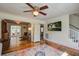 Open living room with hardwood floors, ceiling fan, television, and open access to other rooms at 5615 Highway 165, Ravenel, SC 29470