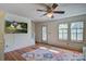 Cozy living room with hardwood floors, ceiling fan, television, and lots of natural light at 5615 Highway 165, Ravenel, SC 29470
