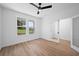 A well-lit bedroom features wood-look floors, and large windows with neighborhood view, accented by white trim at 5655 Captain Kidd Rd, Hollywood, SC 29449