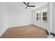 A bright bedroom with wood-look floors, white walls, ceiling fan, and large windows offering a serene outdoor view at 5655 Captain Kidd Rd, Hollywood, SC 29449