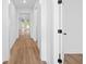 Bright hallway with wood-look floors leading to open space; freshly painted white walls, doors and black hardware at 5655 Captain Kidd Rd, Hollywood, SC 29449