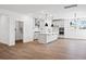 Open-concept kitchen featuring white cabinets, modern pendant lighting, and an island, all accented by sleek, dark hardware at 5655 Captain Kidd Rd, Hollywood, SC 29449