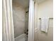Bathroom showcases a tub-shower combo with a white curtain and neutral marble-look tile at 6086 Chisolm Rd, Johns Island, SC 29455