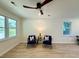 Bright living room with large windows, ceiling fan, and two stylish blue chairs at 6086 Chisolm Rd, Johns Island, SC 29455