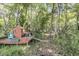 Landscaped backyard featuring a deck with a playhouse and a wooded lot at 707 Jancus St, Charleston, SC 29414