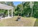 Spacious backyard with a covered patio, a fire pit, and lush landscaping at 707 Jancus St, Charleston, SC 29414