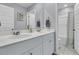 Bright bathroom featuring dual sinks, a large mirror, and a shower with a patterned curtain at 707 Jancus St, Charleston, SC 29414