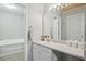 Bathroom with a large mirror, vanity with white cabinets, and a bathtub at 7999 Vermont Rd, North Charleston, SC 29418