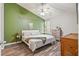 Bright bedroom with a decorative green wall, ceiling fan and wood-look flooring at 7999 Vermont Rd, North Charleston, SC 29418