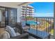 Comfortable balcony seating area overlooking a pool and ocean at 9002 Palmetto Dr # 119, Isle of Palms, SC 29451