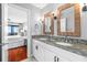 Modern bathroom with double sinks, granite countertop, and a door to an adjoining bedroom at 9002 Palmetto Dr # 119, Isle of Palms, SC 29451