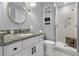Well-lit bathroom with vanity, granite countertop, decorative mirror, and glass door shower at 9002 Palmetto Dr # 119, Isle of Palms, SC 29451