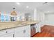 Modern kitchen featuring stainless steel appliances, white cabinets, and seamless access to living space at 9002 Palmetto Dr # 119, Isle of Palms, SC 29451