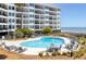 Inviting outdoor pool surrounded by lounge chairs and lush landscaping, steps from the beach at 9002 Palmetto Dr # 119, Isle of Palms, SC 29451