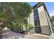 Modern concrete building with dark window frames and doors with mature shade trees and street parking at 1 Cool Blow St # 337, Charleston, SC 29403