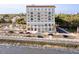Exterior view of a high rise near the water and beach with palm trees at 1 King St # 501, Charleston, SC 29401