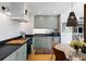 Well-lit kitchen with sage cabinets, black counters, stainless appliances, and stylish lighting fixtures at 1 King St # 501, Charleston, SC 29401