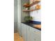 Updated kitchen with sage cabinets, open shelving, dark countertops, and gold hardware at 1 King St # 501, Charleston, SC 29401