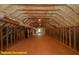 Spacious attic with exposed rafters and beams, featuring insulation and room for storage at 1044 Towhee Ln, McClellanville, SC 29458