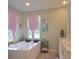 Luxurious bathroom featuring a soaking tub, decorative curtains, and a double vanity at 1044 Towhee Ln, McClellanville, SC 29458